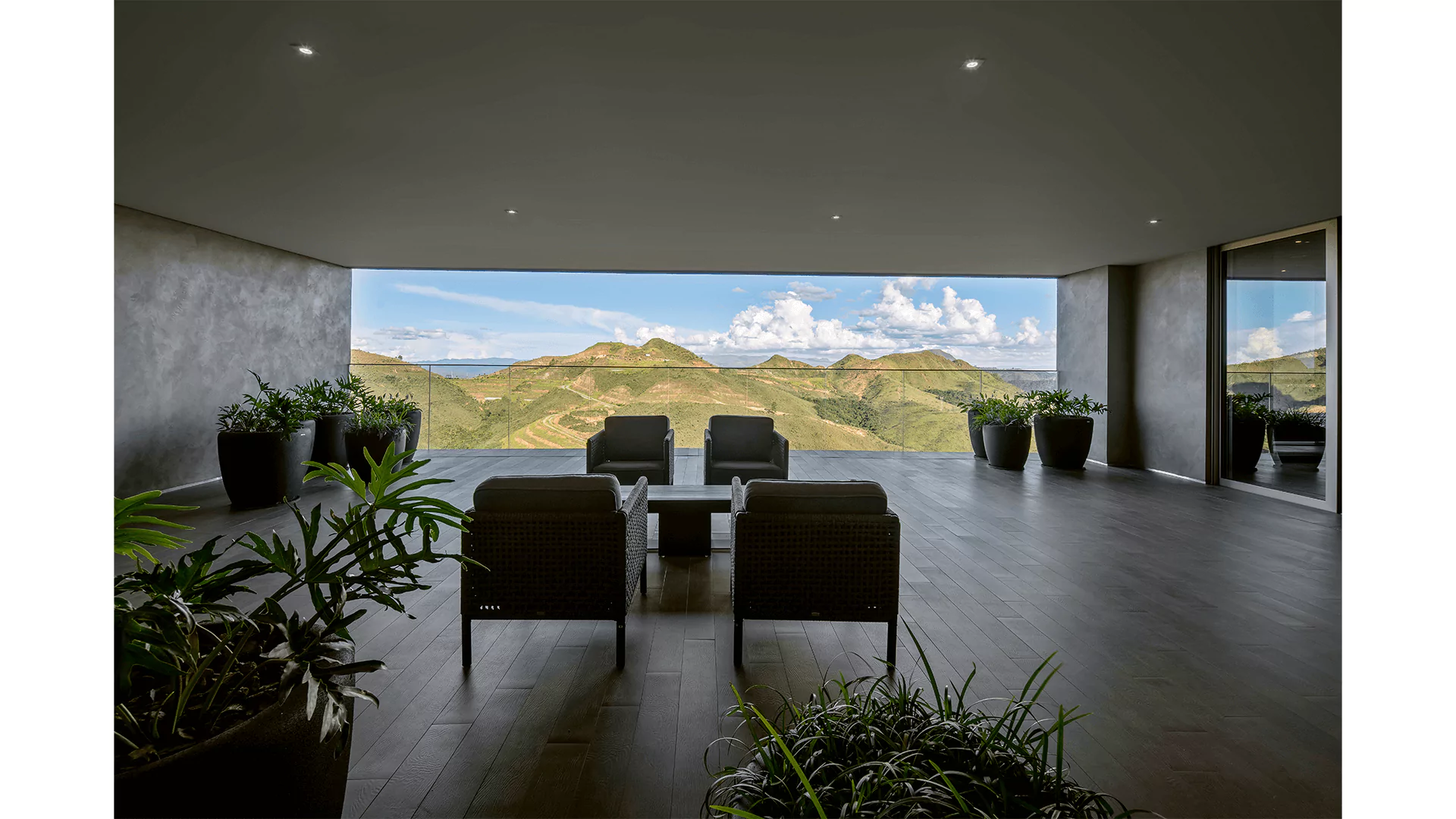Espaço gourmet com poltronas e vista para montanhas