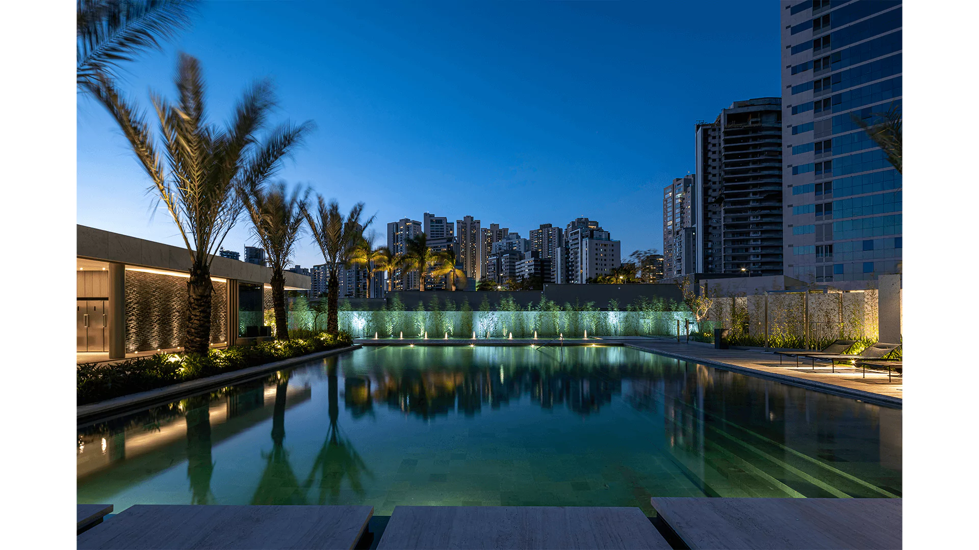 Piscina climatizada e jardins em foto ao entardecer