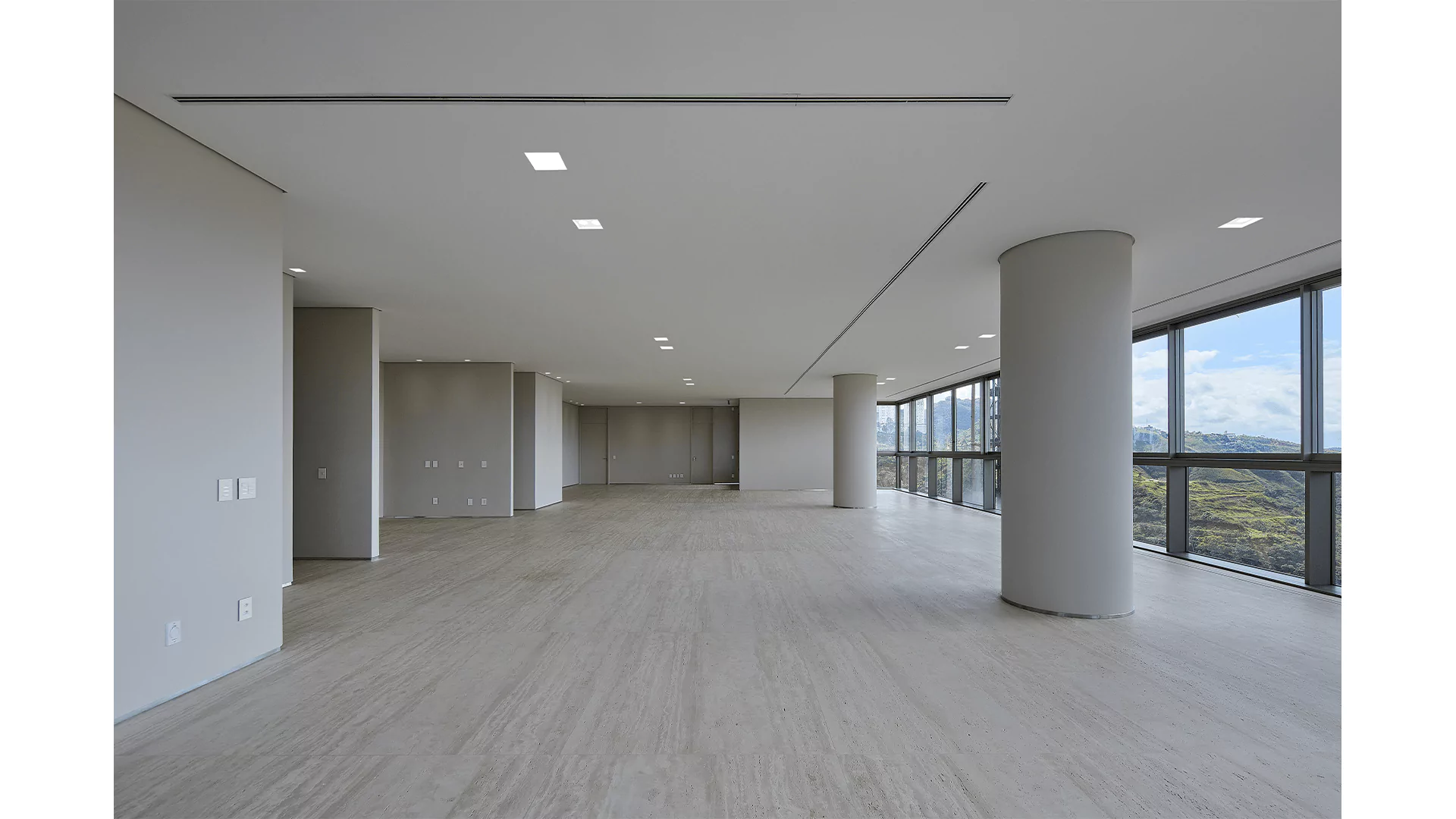 Espaço amplo com colunas e pontos de iluminação